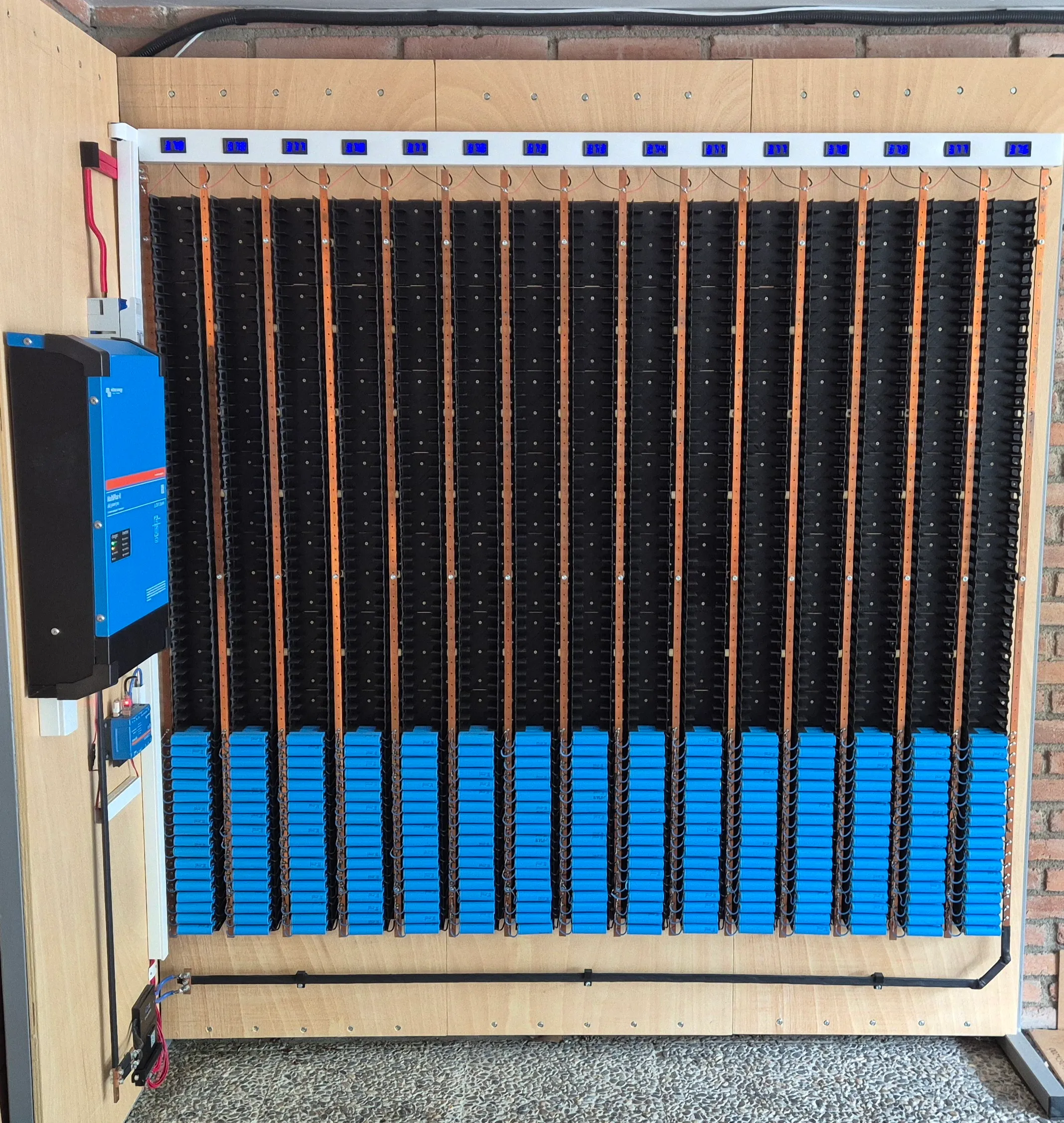 The whole system: 15 series groups of cells, the MultiPlus inverter on the left and the voltage displays on top.