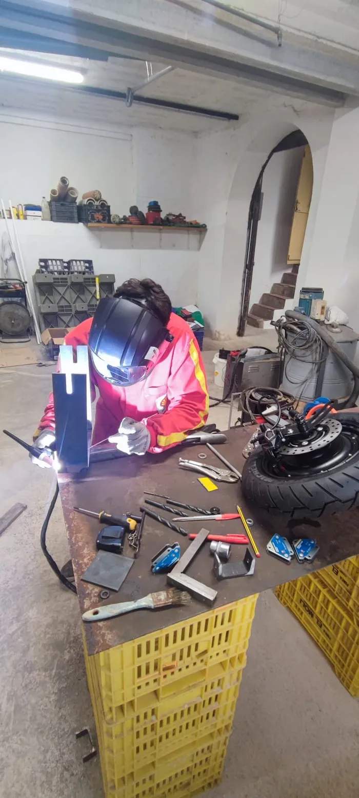 Welding a custom bracket to mount the electric hub motor.